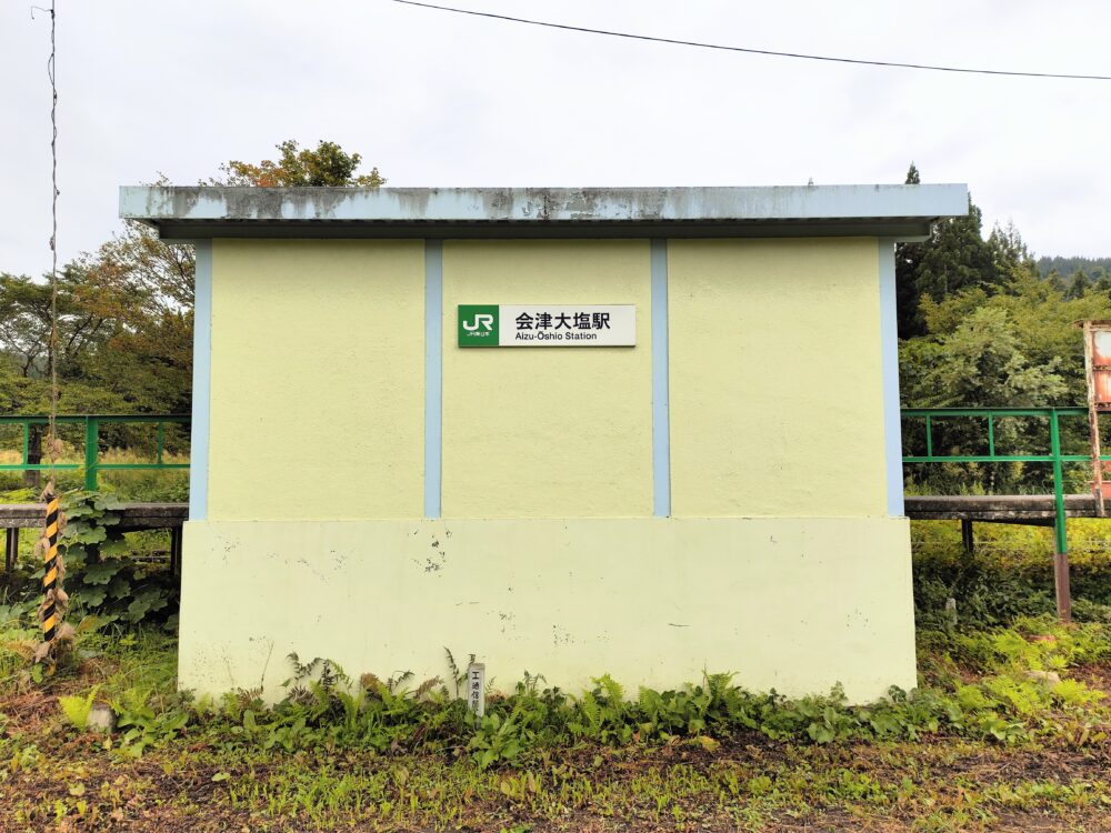 JR会津大塩駅のクリーム色の壁の小さな駅舎の画像