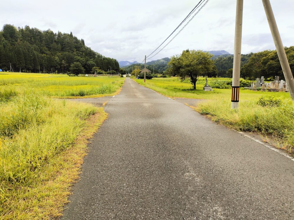 右手に小さな墓地のある十字路の画像