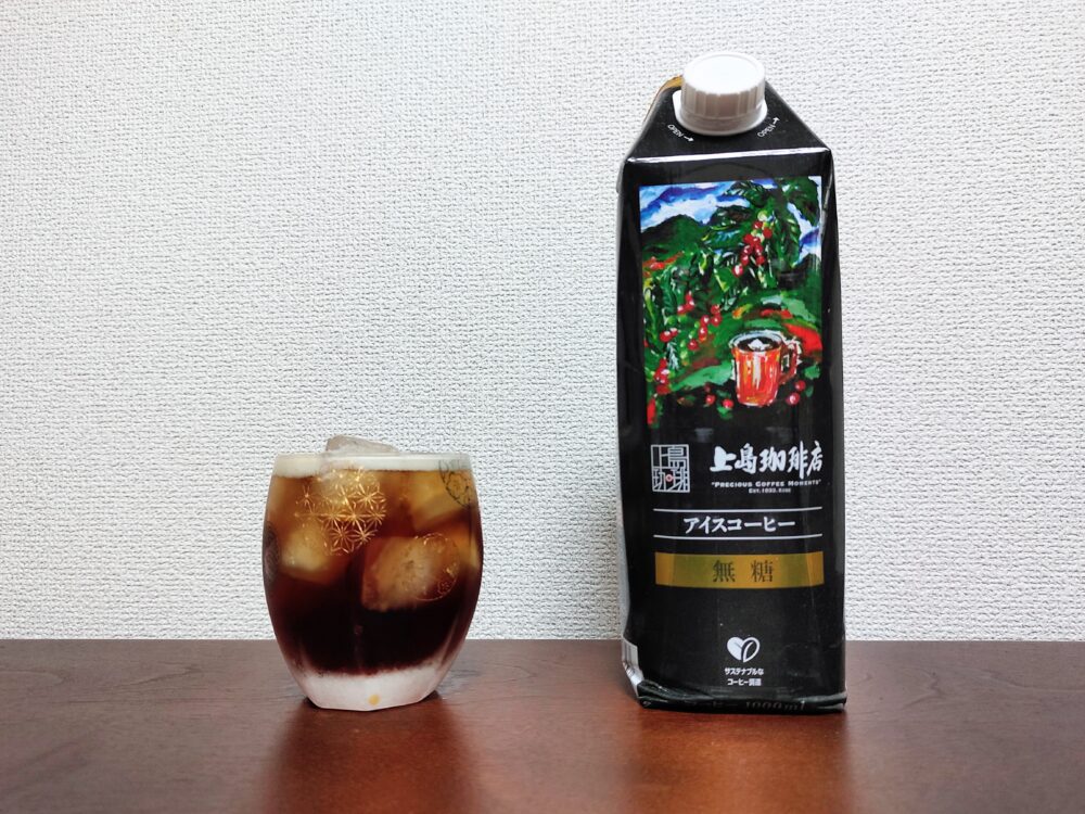 上島珈琲店のアイスコーヒー紙パックと、それで作った炭酸ドリンクを注いだ底の丸いロックグラスを並べた画像