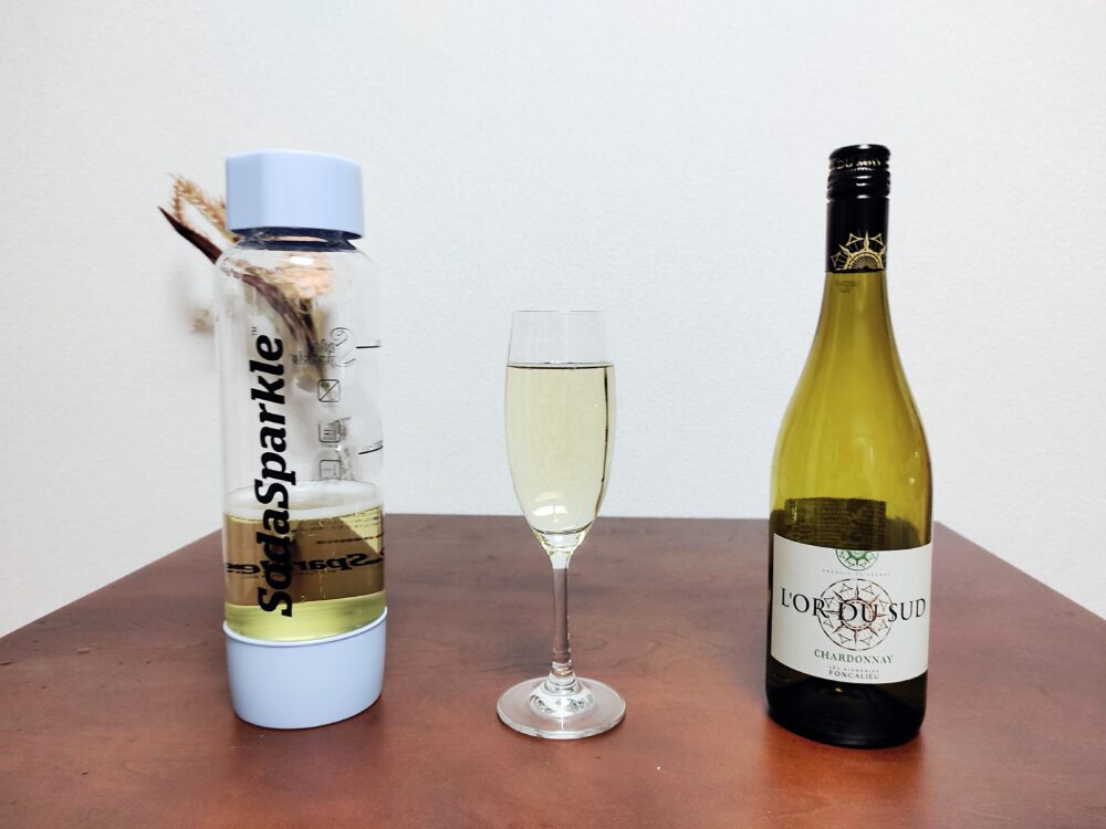 マルチスパークル2を使って作ったスパークリングワインを専用ボトルに入れているもの、グラスに注いだもの、スパークリングワインの元となったワインのボトルを並べて紹介した画像